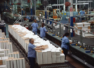 People working on the floor of an industrial plant.